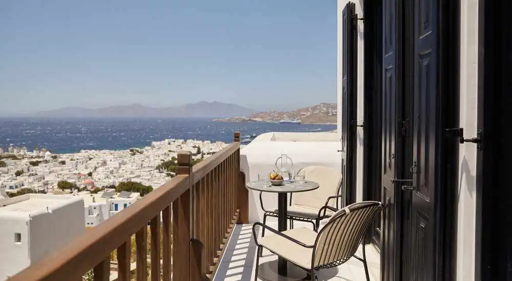 Woman in white kaftan journaling near windmill