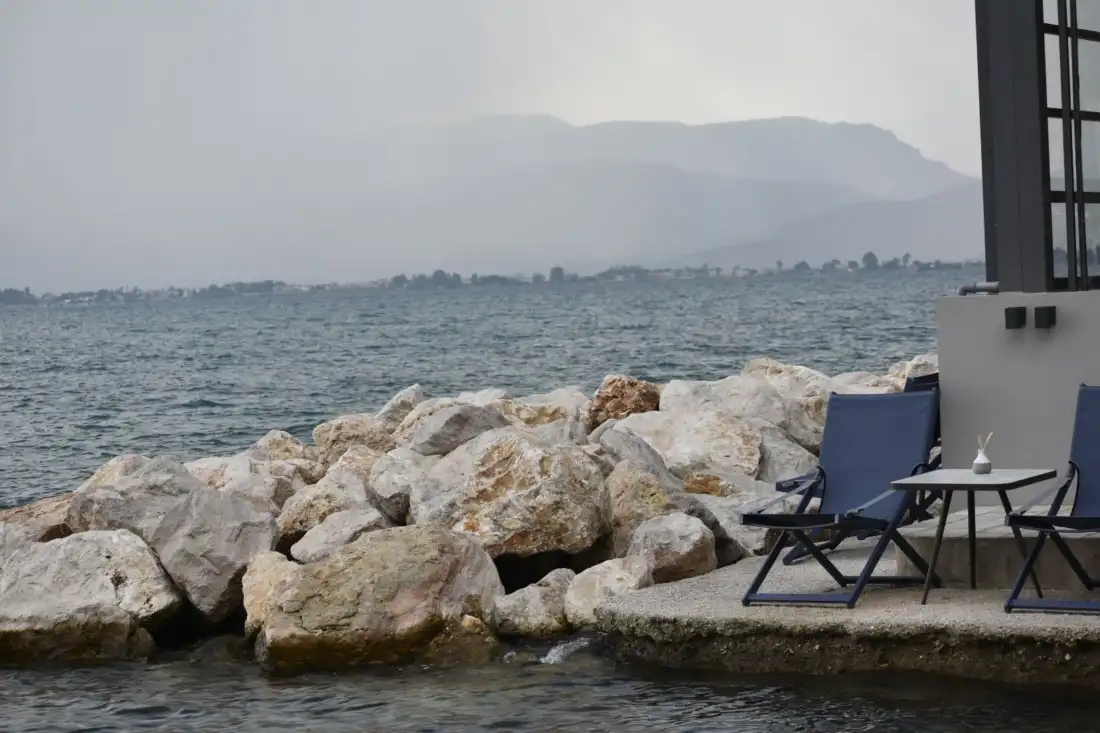 A sunlit view of Nafplio’s harbor with Venetian-style buildings and Bourtzi fortress in the distance.